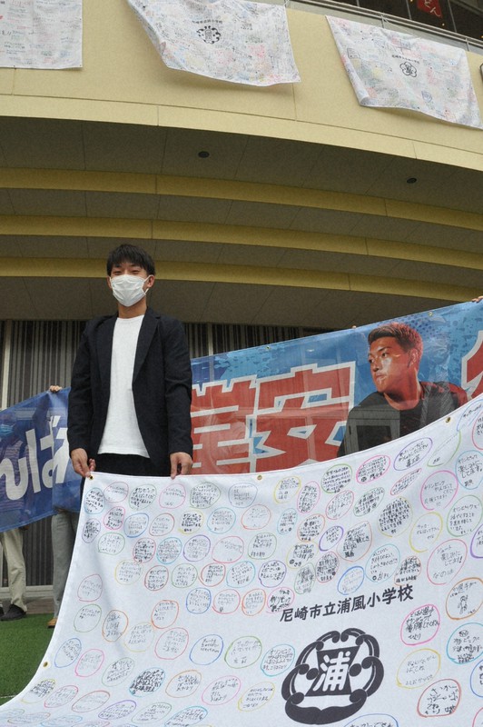堂安律選手への応援旗を持つ堂安憂さん=兵庫県尼崎市潮江のあまがさきキューズモールで2021年7月12日午前11時24分、中村清雅撮影