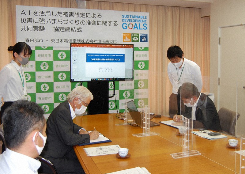 協定書に署名する石川良三市長(左)と花石啓介・NTT東日本埼玉南支店長(右)=春日部市役所で2021年7月12日、古賀三男撮影