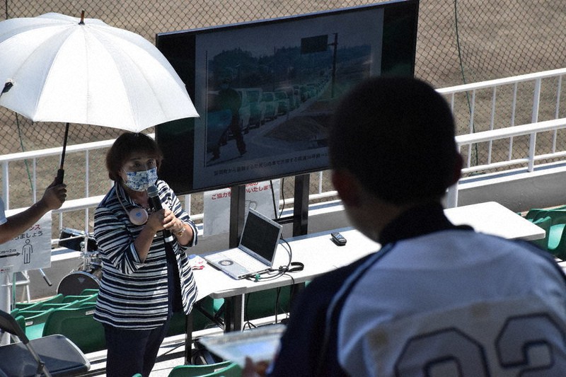 東京オリンピックの開幕を前に実施された野球のイベントで、集まった中学生らに東日本大震災の被災体験を語る青木淑子さん=福島市古川の信夫ケ丘球場で2021年7月17日、肥沼直寛撮影