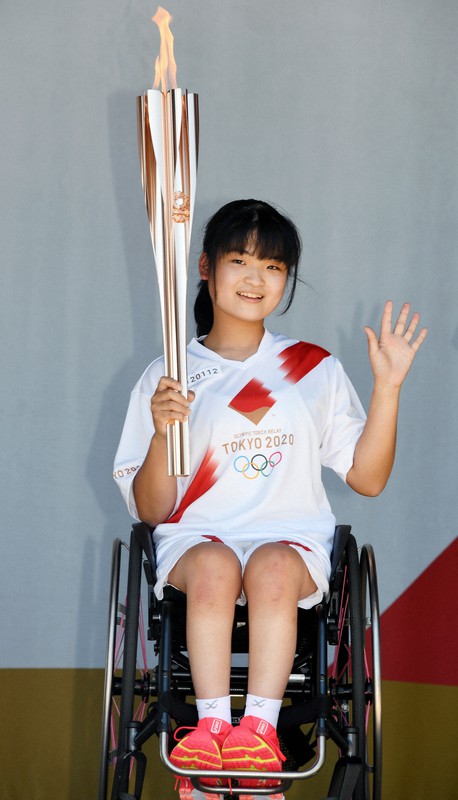 聖火を手に笑顔を見せる増田汐里さん=東京都品川区で2021年7月21日(代表撮影)