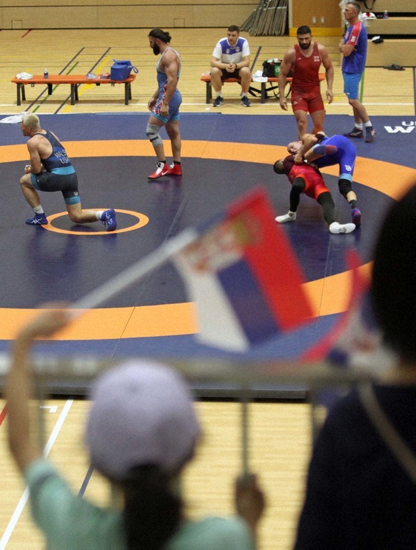 セルビア国旗の小旗を手にした子供たちの前で練習する選手たち=埼玉県富士見市鶴馬の市民総合体育館で2021年7月21日、橋本政明撮影