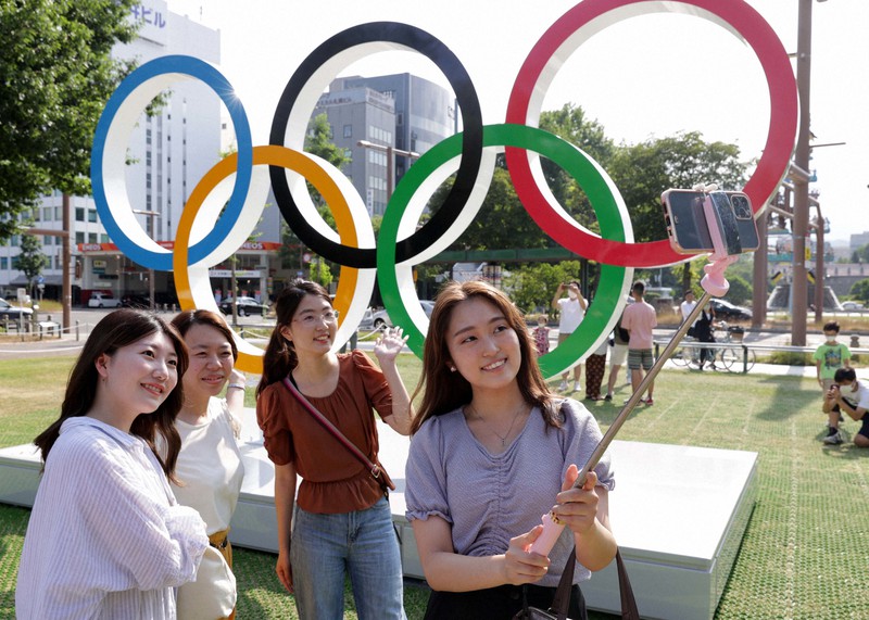 五輪シンボルマークのモニュメント前でスマートフォンを使い自撮りする人たち=札幌市中央区で2021年7月23日午後3時9分、貝塚太一撮影