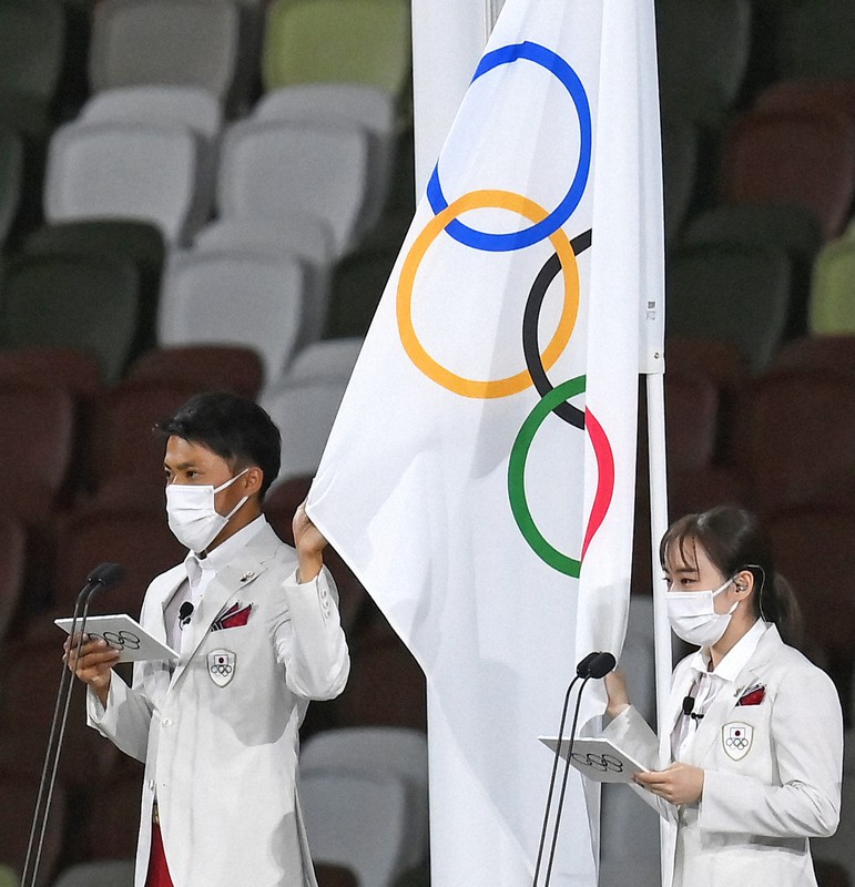 選手宣誓する日本選手団主将の山県亮太(左)と副主将の石川佳純=国立競技場で2021年7月23日午後10時40分、久保玲撮影