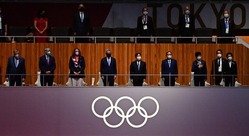 国歌斉唱をお聞きになる天皇陛下。陛下の左隣は国際オリンピック委員会のバッハ会長。右端から橋本聖子・大会組織委員会会長、小池百合子都知事、菅義偉首相=国立競技場で2021年7月23日午後8時18分、徳野仁子撮影