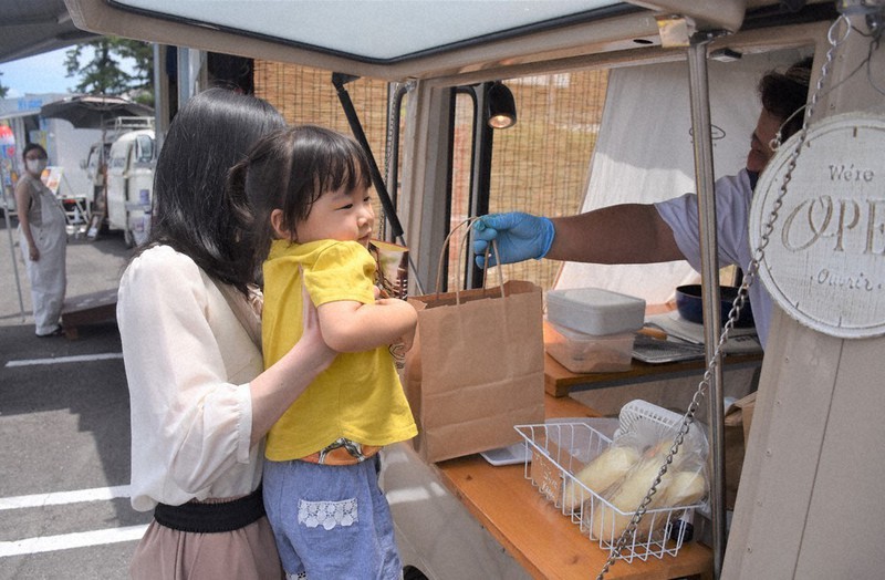 総本山善通寺の駐車場に並ぶキッチンカーでパンを買い求める親子連れ=香川県善通寺市善通寺町3で、西本紗保美撮影