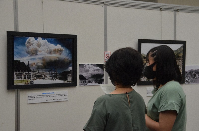 香焼島から撮影され、カラー化したきのこ雲の写真に見入る来場者
