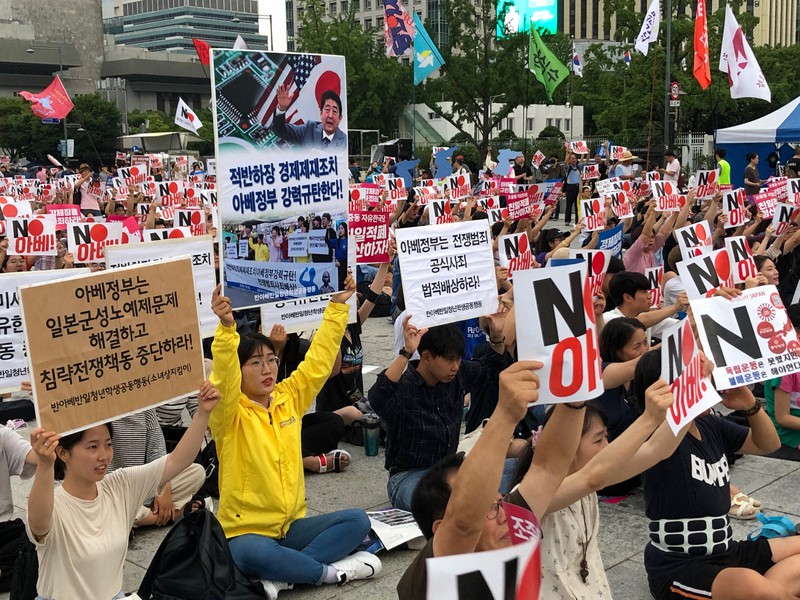 「NO安倍」のプラカードを掲げ、元徴用工問題解決や対韓輸出規制撤回を訴える韓国市民=ソウル市の光化門広場で2019年7月27日、堀山明子撮影
