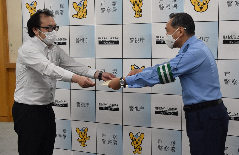 警視庁戸塚署の橋本憲一郎署長(右)から感謝状を受け取る渡部光一さん=東京都新宿区で2021年7月26日午前10時1分、鈴木拓也撮影