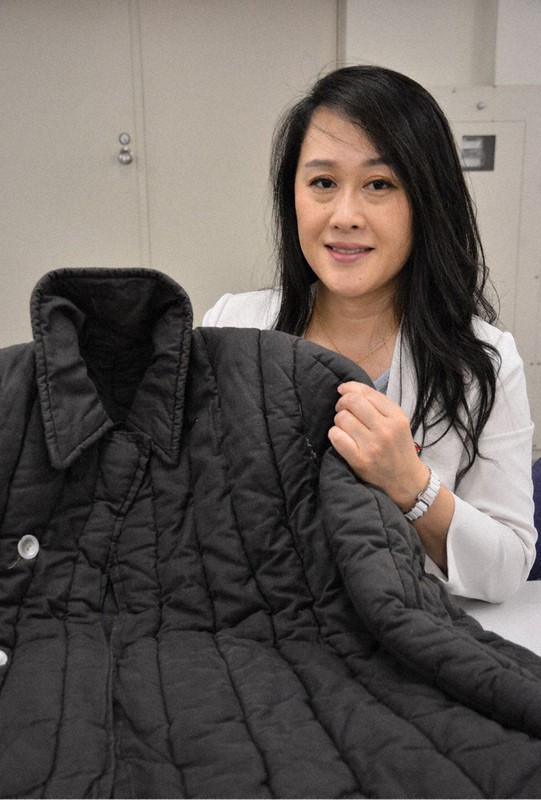 抑留者が帰国する際に配られたコートを手にする建部奈津子さん=札幌市中央区で2021年7月20日、米山淳撮影