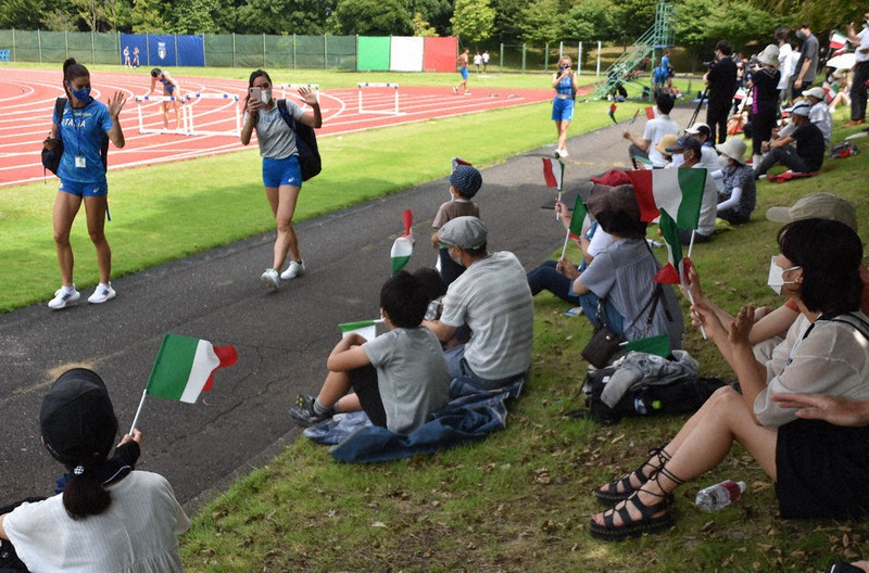 小旗を振る見学者に手を振って応えるイタリアの選手=埼玉県所沢市三ケ島で2021年7月26日、清藤天撮影