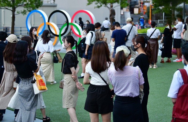 五輪のシンボルマーク前で記念撮影しようと列を作る人たち=東京都新宿区の日本オリンピックミュージアムで2021年7月27日午後6時19分、北山夏帆撮影