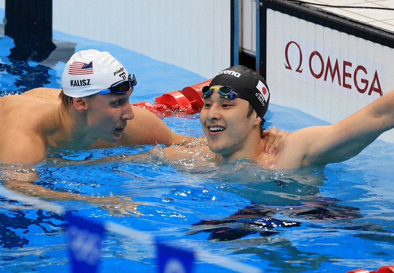 男子200メートル個人メドレー予選、400メートルで優勝したチェース・ケイリシュ(左)にレース後に話しかけられる瀬戸大也=東京アクアティクスセンターで2021年7月28日、梅村直承撮影