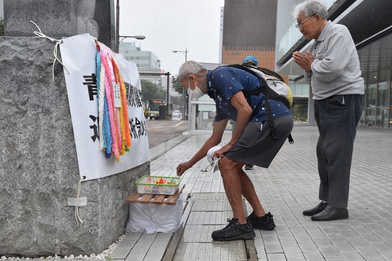空襲の犠牲者に折り鶴を手向け手を合わせる参列者=青森市中央の青森市役所前で2021年7月28日、江沢雄志撮影