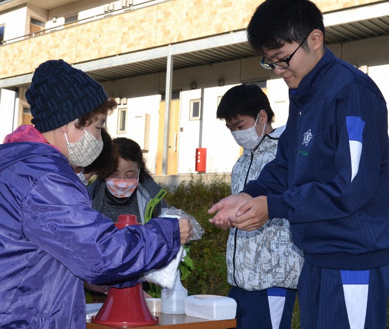 高校生らと津波避難訓練の準備をする大槌町源水自治会(自主防災会)の越田由美子さん(中央)=岩手県大槌町大槌で2020年11月7日、中尾卓英撮影
