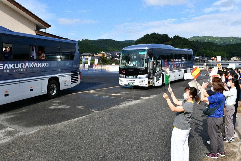 見送りを受けてセレモニー会場を後にする両国チームメンバーを乗せたバス=京丹後市久美浜町で2021年7月28日午前8時13分、松野和生撮影