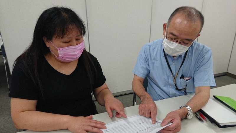 給与明細を手に議論する鈴木真貴さん（左）と仲間の組合員＝東京都文京区で2021年7月3日午後8時、東海林智撮影