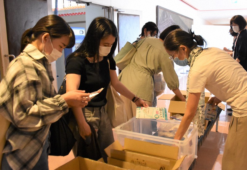 コロナ禍で困窮する学生に向け、食料やマスクなどを学生に配布する教員ら=京都市東山区の京都女子大で2021年7月19日午後0時40分、添島香苗撮影