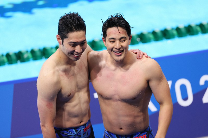 男子200メートル個人メドレー決勝を泳ぎ終え、健闘をたたえ合う4位の瀬戸大也(右)と6位の萩野公介=東京アクアティクスセンターで2021年7月30日、宮武祐希撮影