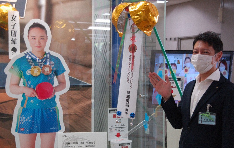 伊藤美誠選手の卓球女子シングルス銅メダルを祝ってくす玉を割った静岡県磐田市の草地博昭市長=同市役所で2021年7月30日、福沢光一撮影