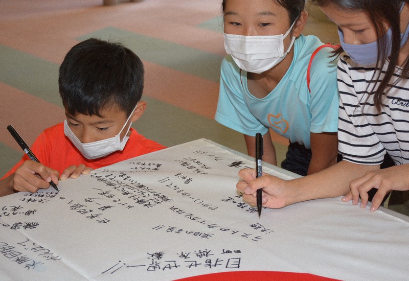 石央文化ホールで開かれたPVで三浦龍司選手に応援メッセージを寄せる子どもたち=浜田市で、萱原健一撮影