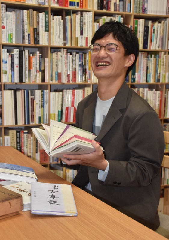 小学校旧校舎を利用した施設内に構えた新会社の事務所で手がけた本を紹介する佐々木良さん=香川県高松市番町1で2021年7月13日午後4時8分、西本紗保美撮影