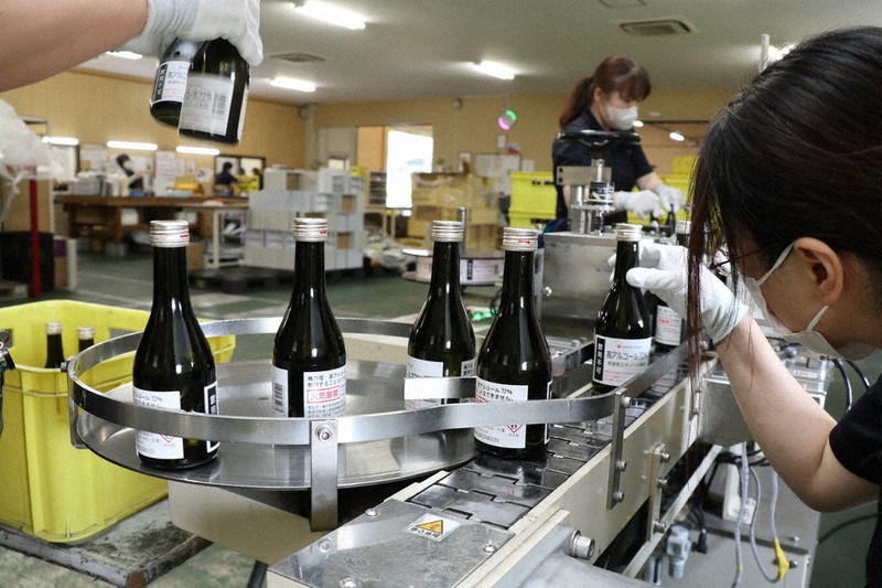 消毒用高濃度アルコールの瓶に貼られた「飲用不可」のラベルを確認する酒蔵の従業員=奈良県葛城市で2020年5月13日午後1時25分、稲生陽撮影