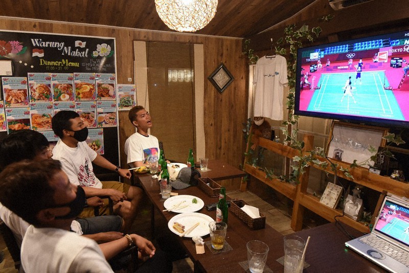 バドミントン男子ダブルス準決勝に出場したインドネシア代表を画面越しに応援する技能実習生=宮城県気仙沼市で2021年7月30日、神内亜実撮影