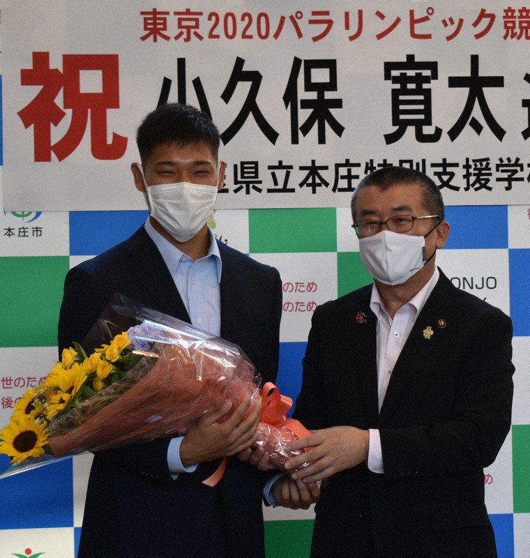 吉田信解市長(右)から花束を贈られ、笑顔を見せる小久保選手=埼玉県本庄市役所で2021年7月27日、中山信撮影