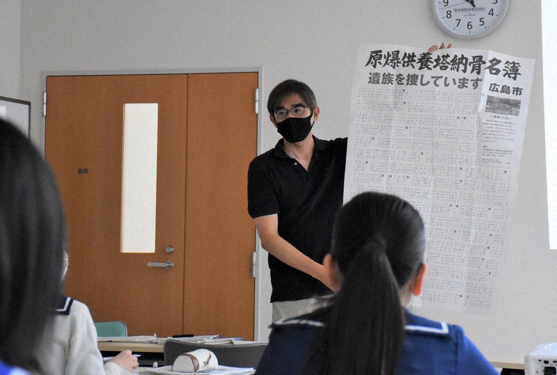 広島市の原爆供養塔に納められ遺族が判明していない遺骨の名簿を見せながら原爆被害について語る青木さん