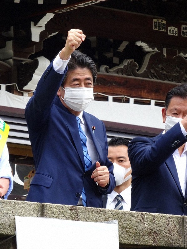 東京都議選の応援で拳を突き上げる自民党の安倍晋三前首相。その一挙手一投足に党内が注目する=東京都荒川区の尾久八幡神社で2021年6月25日午前11時45分ごろ、遠藤修平撮影