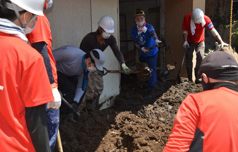 住宅の1階にたまった土砂をスコップでかき出すボランティア=静岡県熱海市伊豆山で2021年8月1日午前11時1分、深野麟之介撮影