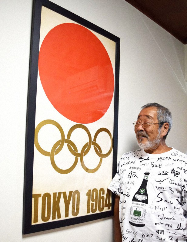大切に額に納められた1964年の五輪ポスター。見つめる北見けんいちさんの表情も和む=東京都新宿区で2021年7月22日、鈴木梢撮影