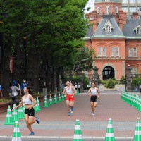 東京五輪のマラソン競技リハーサルで北3条広場（アカプラ）を走る大学生のランナー＝札幌市中央区で2021年8月1日午前7時10分、三沢邦彦撮影