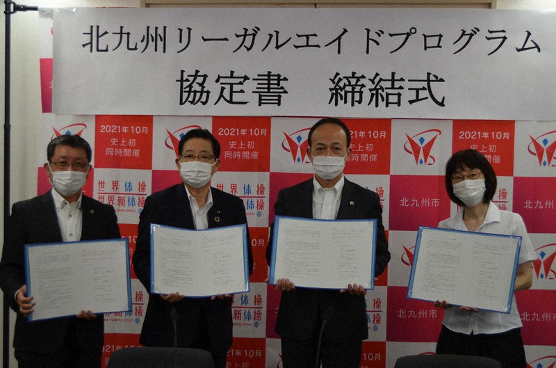 北九州リーガルエイドプログラムの協定書に調印した北橋健治市長(左から2人目)と伊藤・県弁護士会長(同3人目)ら