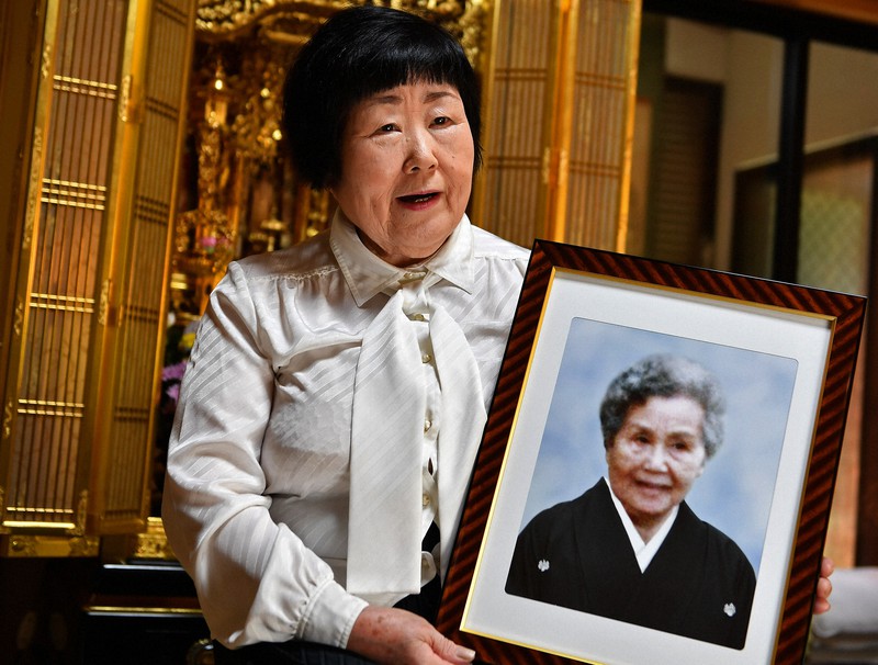 母サダ子さんの遺影を手に、被爆体験を振り返る次女の脇舛友子さん=広島県熊野町で2021年8月4日、山田尚弘撮影