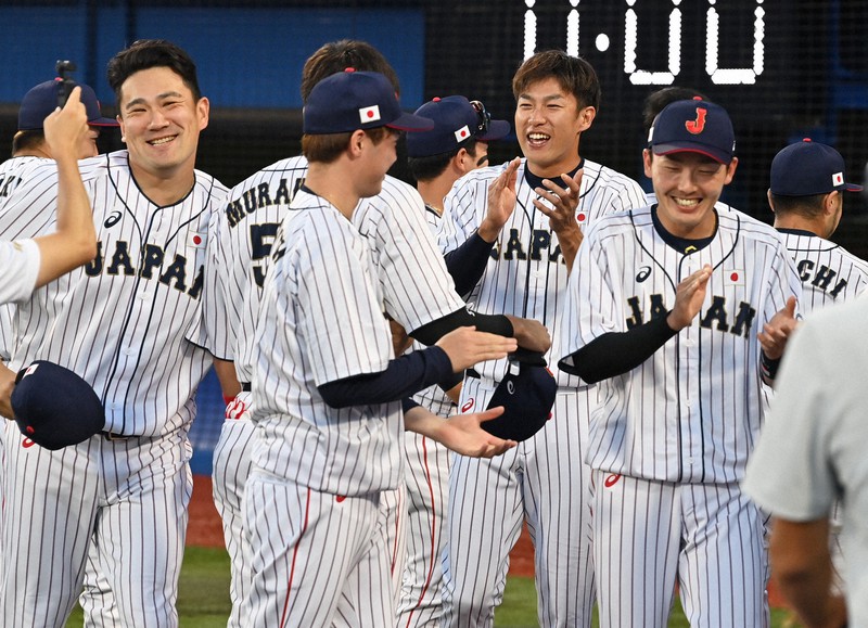 【日本-韓国】試合前の円陣で笑顔を見せる田中将大(左)や柳田悠岐(中央右)ら日本の選手たち=横浜スタジアムで2021年8月4日、大西岳彦撮影