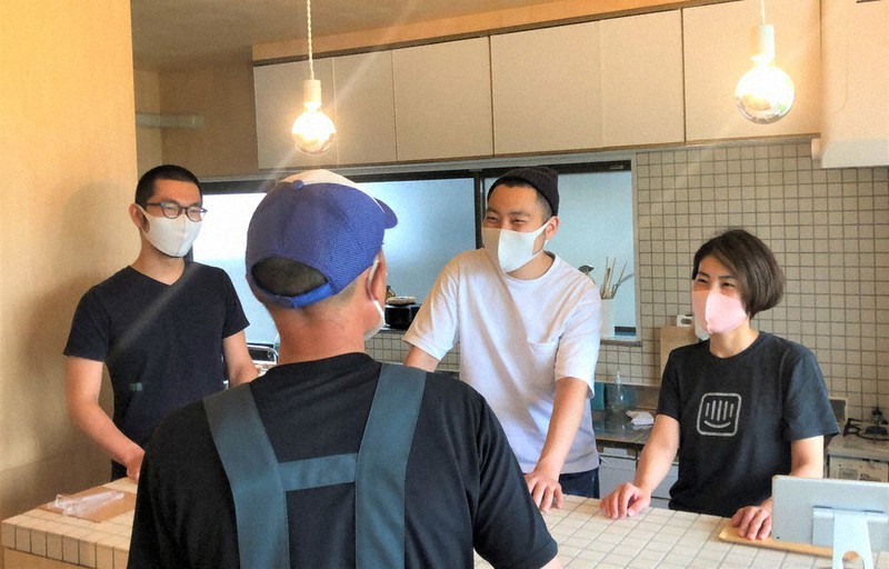 新作の醸造酒を買いに来た地元客と談笑するhaccobaの(左から)立川哲之さんと、佐藤太亮さん・みずきさん夫婦=福島県南相馬市小高区田町で2021年7月12日午後4時21分、尾崎修二撮影