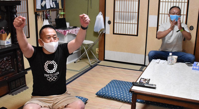 川井友香子選手の金メダルが決まり、ガッツポーズで喜ぶ金沢ジュニアレスリングクラブの筒井昭好代表(左)ら=金沢市で2021年8月4日午後9時29分、井手千夏撮影