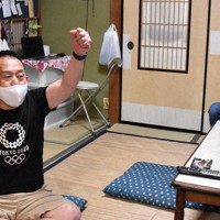 川井友香子選手の金メダルが決まり、ガッツポーズで喜ぶ金沢ジュニアレスリングクラブの筒井昭好代表（左）ら＝金沢市で、井手千夏撮影