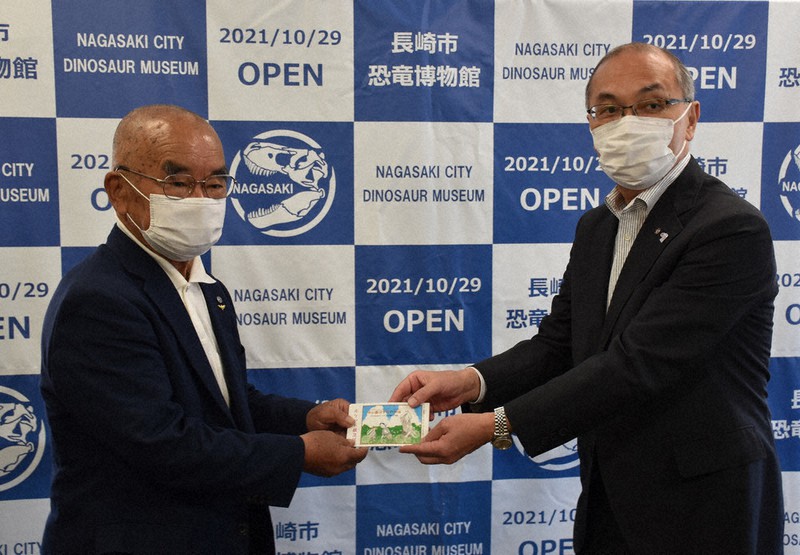 ポケット紙芝居を寄贈する本田会長(左)