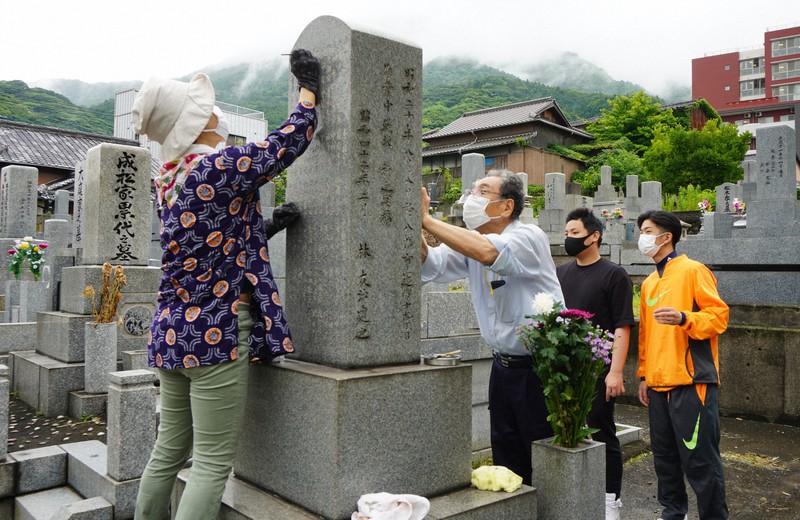 龍潜寺境内にある慰霊碑に墨入れをする(左から)平野塾の出口さん、出來谷さん、九州国際大の河野さん、山崎さん=北九州市八幡東区で2021年7月2日午前9時20分、奥田伸一撮影
