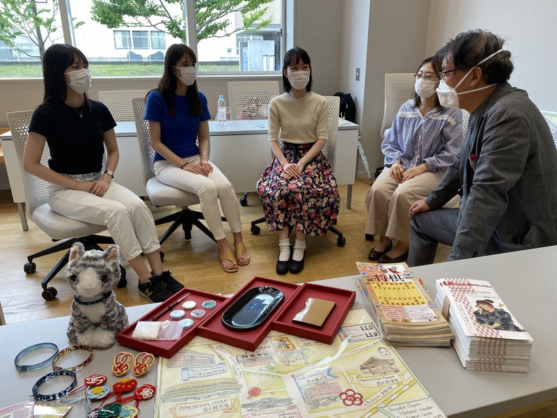 津田塾大学の学生たちと曽根原登教授(右端)。手前にあるのは梅五輪プロジェクトで作った英語のパンフレットや地図、福井県鯖江市などの連携自治体と作った特産品=東京都渋谷区千駄ケ谷で2021年7月13日午後2時20分、松倉佑輔撮影