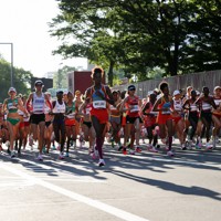 開始時刻が1時間早まった女子マラソン。朝日を背に受け一斉にスタートする選手たち＝札幌市大通公園で2021年8月7日、貝塚太一撮影