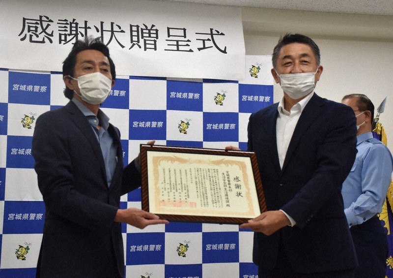 一般社団法人コンテンツ海外流通促進機構の後藤健郎代表理事(左)から感謝状を受け取る赤間博之生活安全課長=宮城県警の塩釜署で2021年8月4日、面川美栄撮影