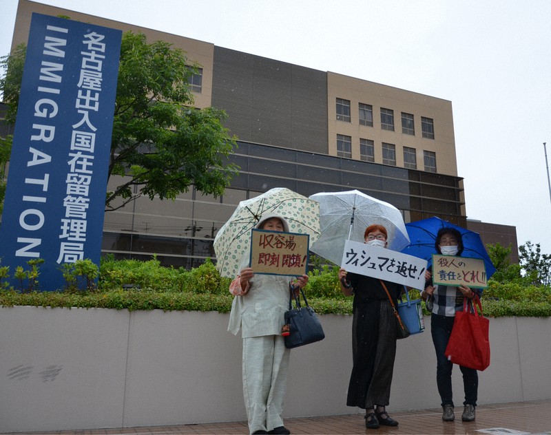 名古屋入管前に立ち、抗議の意思を表す真野明美さん(中央)ら=名古屋市港区で2021年8月13日午前11時20分、川瀬慎一朗撮影
