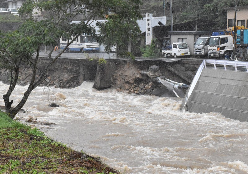 大雨で鈴張川が増水し、道路の一部が崩落。ガードレールも折れ曲がった=安佐北区安佐町飯室で、根本佳奈撮影