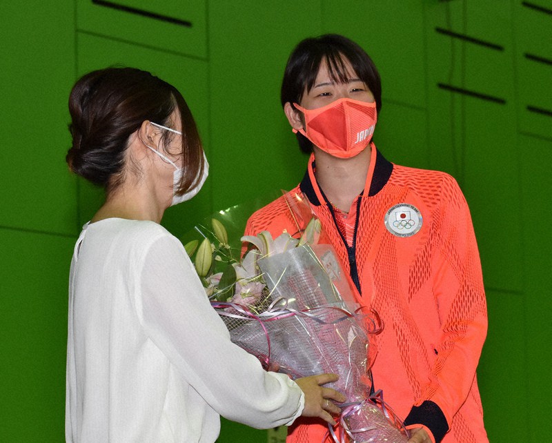 報告会で花束を受け取り、笑顔を見せる永原選手(右)=北海道芽室町で2021年8月13日、鈴木斉撮影