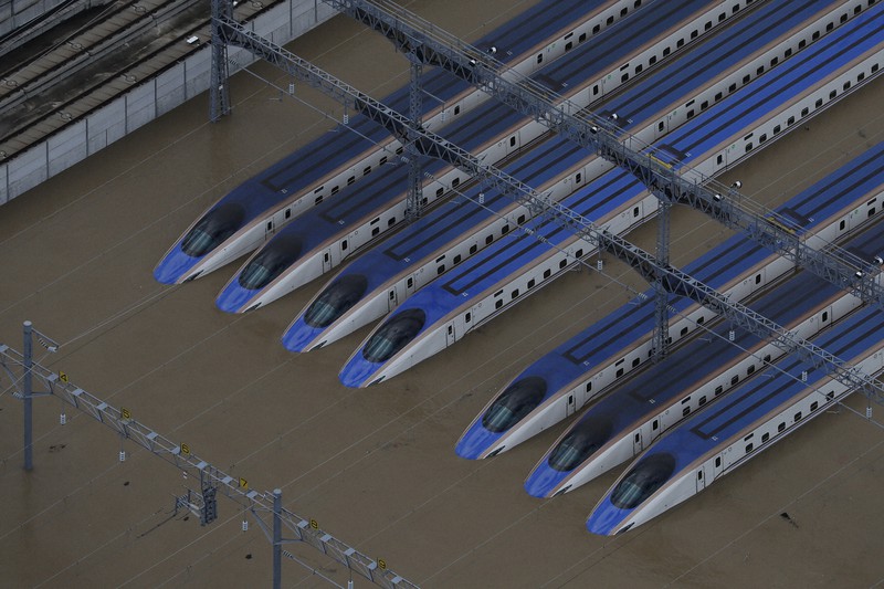 2019年の台風19号の影響で浸水した車両基地に並ぶ北陸新幹線の車両=長野市赤沼で2019年10月13日、本社ヘリから