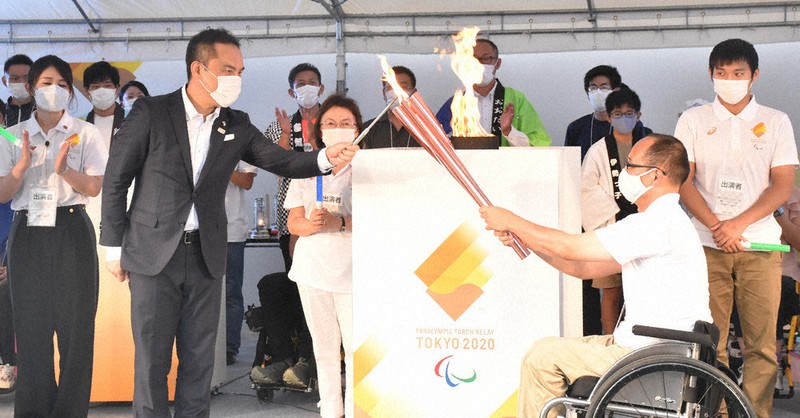 鈴木英敬知事が「三重県の火」を出立者の前田浩司さんの持つトーチに点火した=津市一身田上津部田の県総合文化センターで2021年8月15日、寺原多惠子撮影
