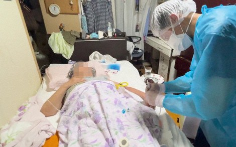 高熱や息苦しさを訴える女性に対し、ステロイド剤の注入や採血を行う菊池医師(右)=ファストドクター提供(画像の一部を加工しています)